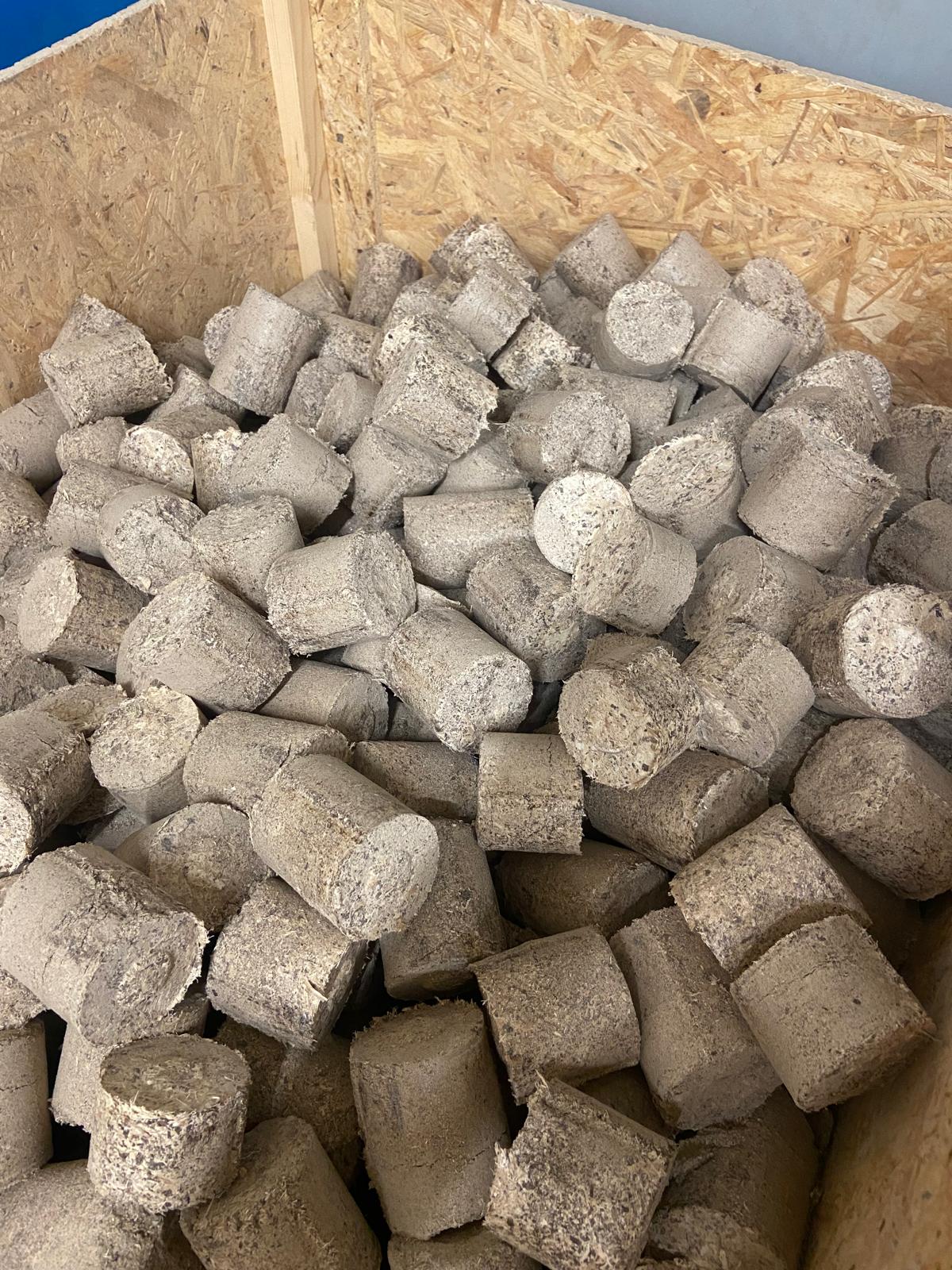 Bûchettes de copeaux de bois compactés alimentant la chaudière de l'atelier